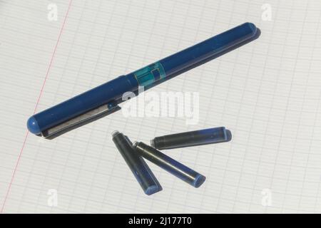 School supplies, pen, blue ink cartridge and lined paper sheet Stock Photo