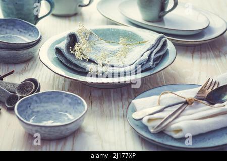 Stoneware kitchen utensils - sustainability. Assortment of plates, bowls and cups from natural materials. Stock Photo