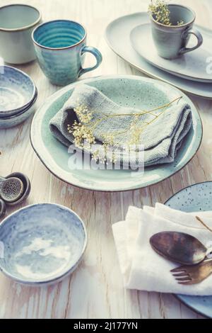 Stoneware kitchen utensils - sustainability. Assortment of plates, bowls and cups from natural materials. Stock Photo