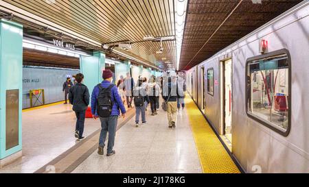 Large group of people walking in the subway platform in York Mills Station. A new Bombardier train is seen to the right. Stock Photo