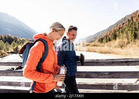 Austria, Alps, happy couple on a hiking trip crossing a bridge Stock Photo