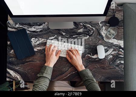 Young man working on desktop PC at home Stock Photo