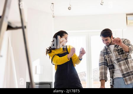 Happy young couple dancing in living room Stock Photo