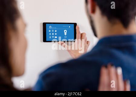 Heterosexual couple using IOT home app through tablet computer at new home Stock Photo