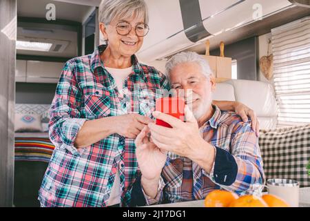 Smiling senior couple using smart phone at motor home Stock Photo