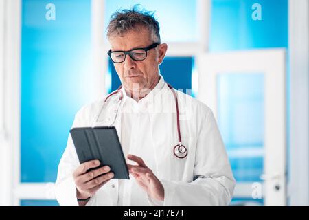 Doctor with stethoscope using digital tablet PC at clinic Stock Photo