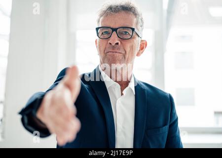 Businessman offering handshake at work place Stock Photo