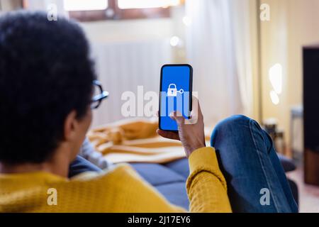 Woman using mobile phone at home Stock Photo