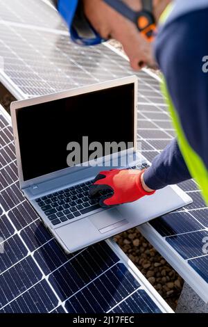 Engineer working on laptop over solar panels Stock Photo
