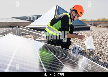 Technician assembling and installing solar panels on sunny day Stock Photo