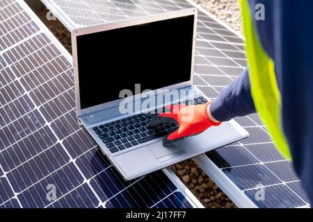 Technician working on laptop over solar panels Stock Photo