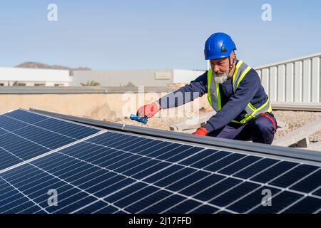 Technician installing solar panels on sunny day Stock Photo