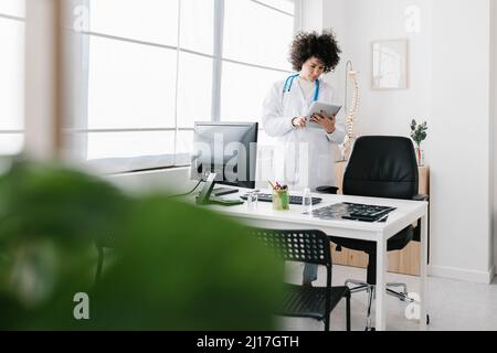 Doctor using tablet PC standing at medical clinic Stock Photo
