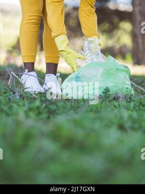 Environmentalist collecting plastic bottles at park Stock Photo