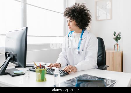 Young doctor using desktop PC in hospital Stock Photo