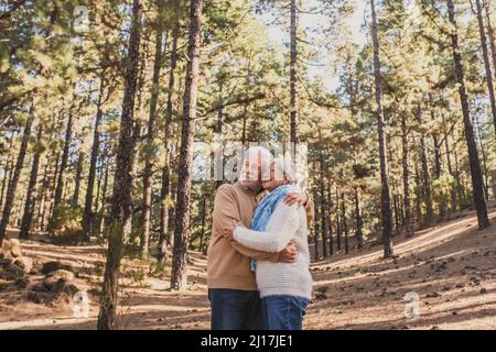 Happy senior couple hugging each other in forest Stock Photo