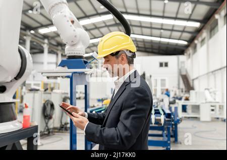 Engineer using tablet PC standing in factory Stock Photo