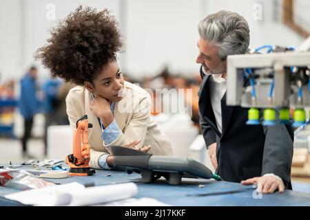 Engineers talking with each other standing in factory Stock Photo
