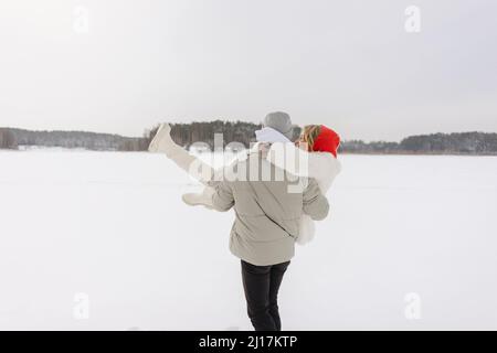 Man carrying woman standing on snow Stock Photo