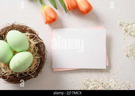 Easter greeting card with green eggs in decorative nest on white background. View from above. Greeting card with copy space. Stock Photo