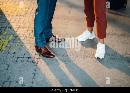 Business colleagues wearing shoes standing on footpath Stock Photo