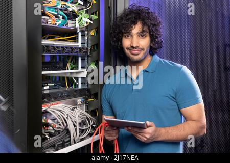 Smiling IT support holding tablet PC standing in server room Stock Photo