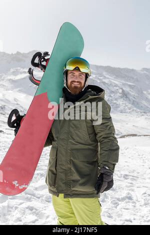 Smiling young man standing with snow board Stock Photo