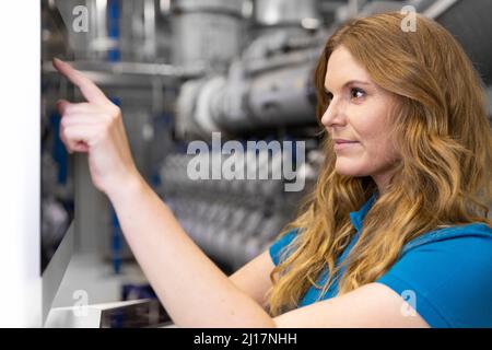 IT support typing on touch screen device in factory Stock Photo