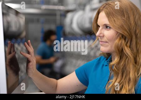 IT support using touch screen device in factory Stock Photo