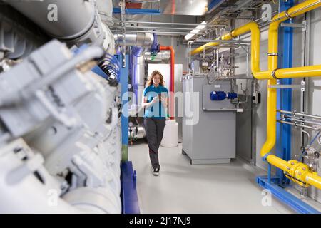 Technician using tablet PC walking in factory Stock Photo