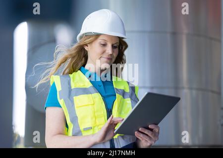 Technician using tablet PC standing in industry Stock Photo