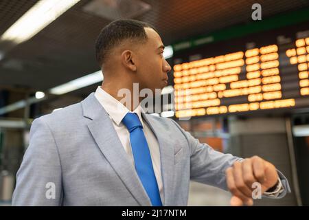 Businessman checking time waiting at train station Stock Photo