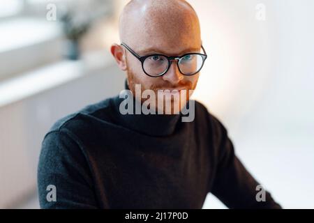 Confident businessman wearing eyeglasses sitting in office Stock Photo