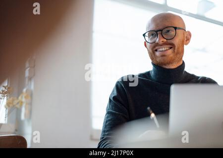 Happy working man sitting with laptop in office Stock Photo