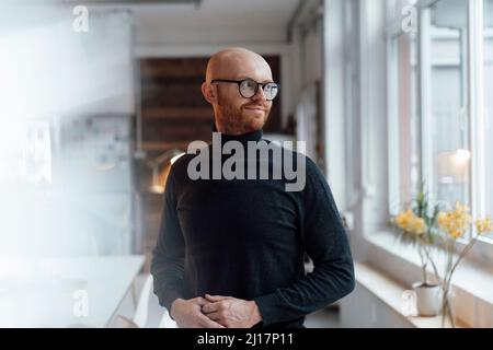 Young bald working man standing in office Stock Photo