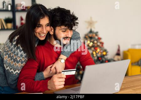 Happy couple doing online shopping using laptop at home Stock Photo