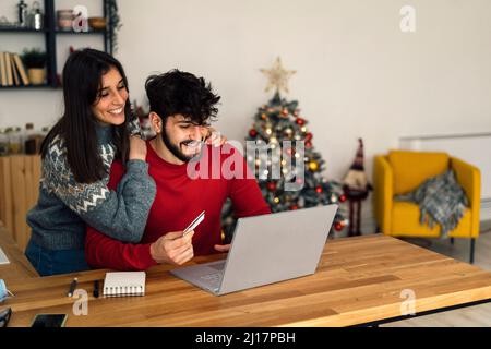 Happy couple doing online shopping through laptop at home Stock Photo