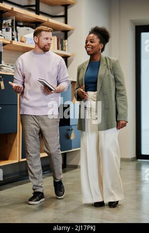 Businessman talking with colleague walking in office Stock Photo