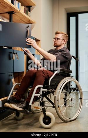 Disabled businessman searching documents in cabinet at office Stock Photo