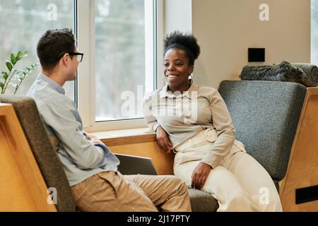 Happy business colleagues talking to each other at office Stock Photo