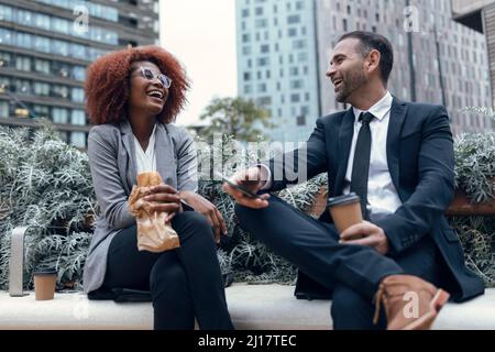 Two business colleagues talking while sitting outdoors Stock Photo