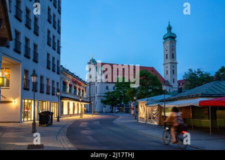 Germany, Bavaria, Munich, Viktualienmarkt at dusk with Heilig-Geist-Kirche in background Stock Photo