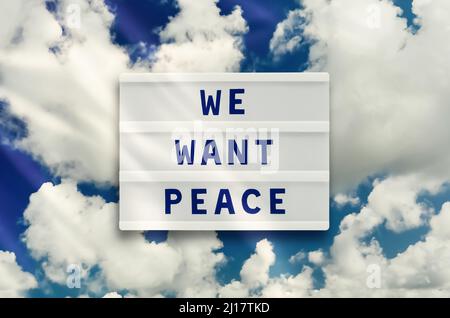 WE WANT PEACE written in a lightbox on clouds sky background. No war concept. Stock Photo