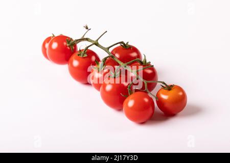 Close-up of fresh red cherry tomatoes twig against white background Stock Photo