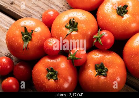 Directly above view of fresh red tomatoes with water drops on table Stock Photo