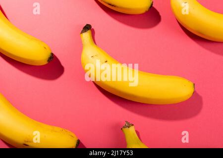 Overhead view of fresh bananas on pink background Stock Photo