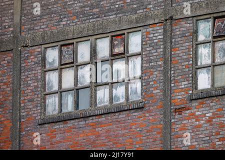 Abandoned and destroyed industrial plant factory, showing the old windows in a red brick wall. High quality photo