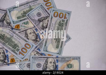 Closeup view of several 100 dollar bills randomly laying flat showing the front and back sides in a cluster for copy space or background Stock Photo