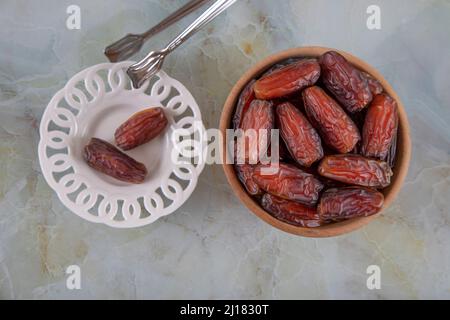 Date fruit in two bowl on colorful marble background, top view Stock Photo