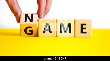 Name of the game symbol. Wooden blocks with concept words Name Game. Businessman hand. Beautiful yellow table white background. Business and name of t Stock Photo